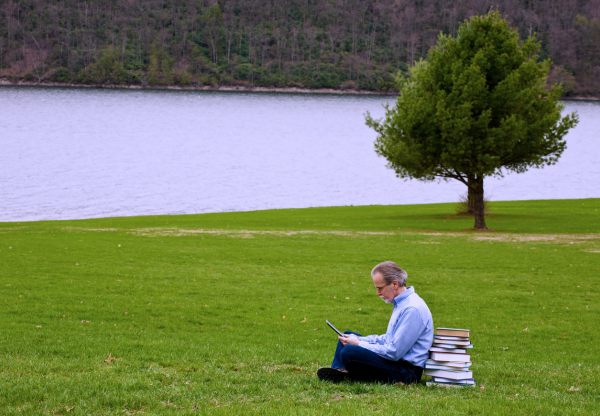 një Një burrë duke lexuar në natyrë